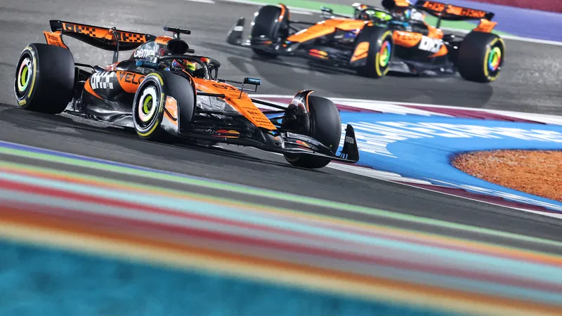 รถแข่ง McLaren F1 สีส้ม-ดำ ขณะวิ่งบนสนามแข่ง F1 ฤดูกาล 2025